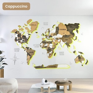 Op de afbeelding: Een grote houten wereldkaart als wanddecoratie in bruin- en beigetinten met verlichte randen. De kaart toont gelabelde continenten, landen en oceanen, geaccentueerd door kleine houten uitsparingen van vliegtuigen en zeilboten op de muur.