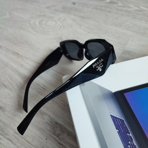 Weiße Prada-Sonnenbrille aus Acetat mit Logo an der Seite und eingravierter Prada-Brille auf der linken Linse. Prada-Sonnenbrille Bild 4