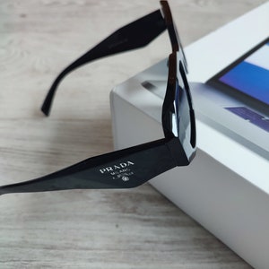 Prada black sunglasses in acetate with the logo on the side and engraved on the left lens Prada glasses prada milan sunglasses