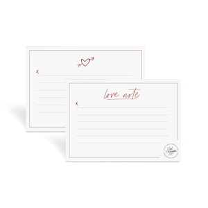 Peut inclure: Deux cartes blanches vierges avec des lignes rouges et un cœur rouge avec une flèche sur la carte du dessus. La carte du dessous porte les mots "love note" écrits en cursive rouge. La carte du dessous a un tampon rouge avec les mots "Real Moments" en noir.
