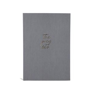 May include: A gray notebook with the text "the grey dots" written in gold lettering.