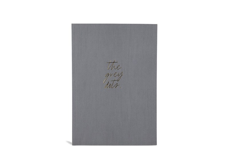 May include: A gray notebook with the text "the grey dots" written in gold lettering.