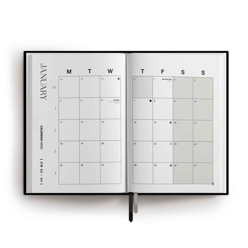 May include: An open planner showing a January calendar spread with white pages and black text. The left page displays the month name, calendar week, and dates. The right page features a grid with shaded weekend columns and lunar phase icons.