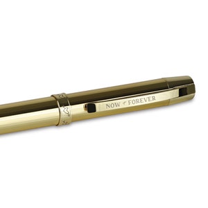 May include: Gold pen with a heart design on the barrel and the words "NOW + FOREVER" engraved on the side.