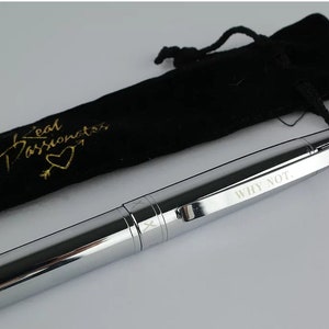 May include: A silver pen with the words "WHY NOT." engraved on the side. The pen comes with a black velvet pouch with the words "Real Passionistas" and a heart design in gold lettering.