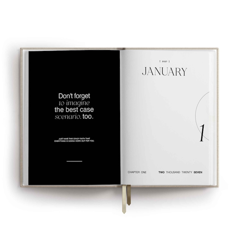 May include: An open planner with a black left page featuring the white text Don't forget to imagine the best case scenario. too. and a white right page labeled JANUARY 2027 with the number 1, CHAPTER ONE, and TWO THOUSAND TWENTY SEVEN.
