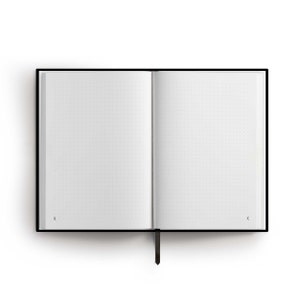 May include: A black hardcover notebook with a black ribbon bookmark. The notebook is open to a blank page with a dotted grid pattern.