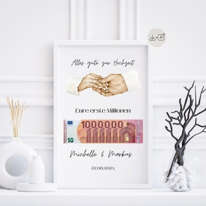 Puede incluir: Una impresión enmarcada en blanco con una ilustración de acuarela de dos manos que se sostienen con anillos en sus dedos. El texto "Alles gute zur Hochzeit" está en la parte superior de la impresión. Debajo de las manos hay un billete de 100.000 euros con el texto "Eure erste Millionen" encima. Los nombres "Michelle & Markus" y la fecha "22.06.202X" están en la parte inferior de la impresión.