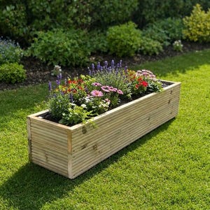 May include: A rectangular wooden planter box constructed from horizontal ribbed planks. The planter is filled with a variety of colourful flowers, including purple lavender, pink coneflowers, and small red blossoms, set against a green lawn background.