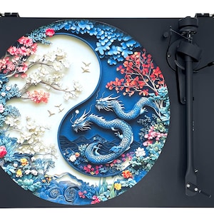 Könnte beinhalten: Ein schwarzer Plattenspieler mit einer runden, bunten Schallplatte mit einem Yin-Yang-Design mit Drachen und Blumen. Die Schallplatte ist ein 3D-Papierkunstdesign.