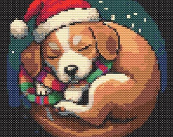 May include: A brown and white puppy wearing a red Santa hat and a colorful scarf is curled up asleep against a dark blue background with white snowflakes.