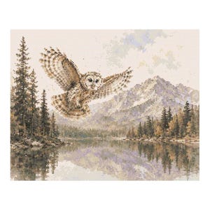 May include: A cross-stitch landscape depicts a brown owl in flight over a lake, with mountains and evergreen trees in the background. The owl's wings are spread, and the scene is reflected in the water. The color palette is muted, with shades of brown, green, and blue.