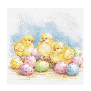 Puede incluir: Tres pollitos amarillos rodeados de huevos de Pascua coloridos. Los pollitos se miran y los huevos.