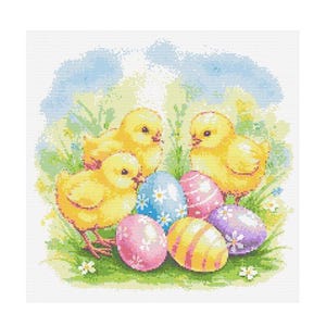 Puede incluir: Tres pollitos amarillos rodeados de huevos de Pascua coloridos. Los huevos están decorados con rayas, lunares y motivos florales.