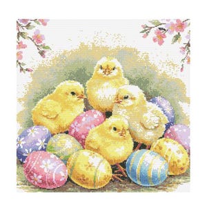 Puede incluir: Cinco pollitos amarillos acurrucados entre coloridos huevos de Pascua. Los pollitos están rodeados de una variedad de huevos de colores pastel, incluyendo rosa, azul, amarillo y verde.