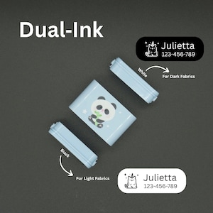 May include: A light blue dual-ink label maker with a panda design, accompanied by two ink cartridges, one black for light fabrics and one white for dark fabrics. Includes labels with the name "Julietta" and a phone number.