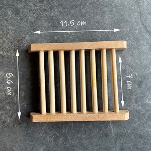 Op de afbeelding: Een houten zeepbakje met een lamellenontwerp. Het bakje is 11,5 cm breed, 8,6 cm lang en 7 cm hoog.