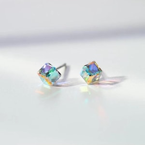 May include: A pair of silver stud earrings with iridescent blue and green cube-shaped crystals.