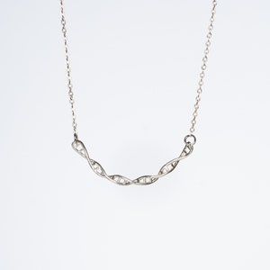 May include: A silver necklace with a double helix DNA pendant.