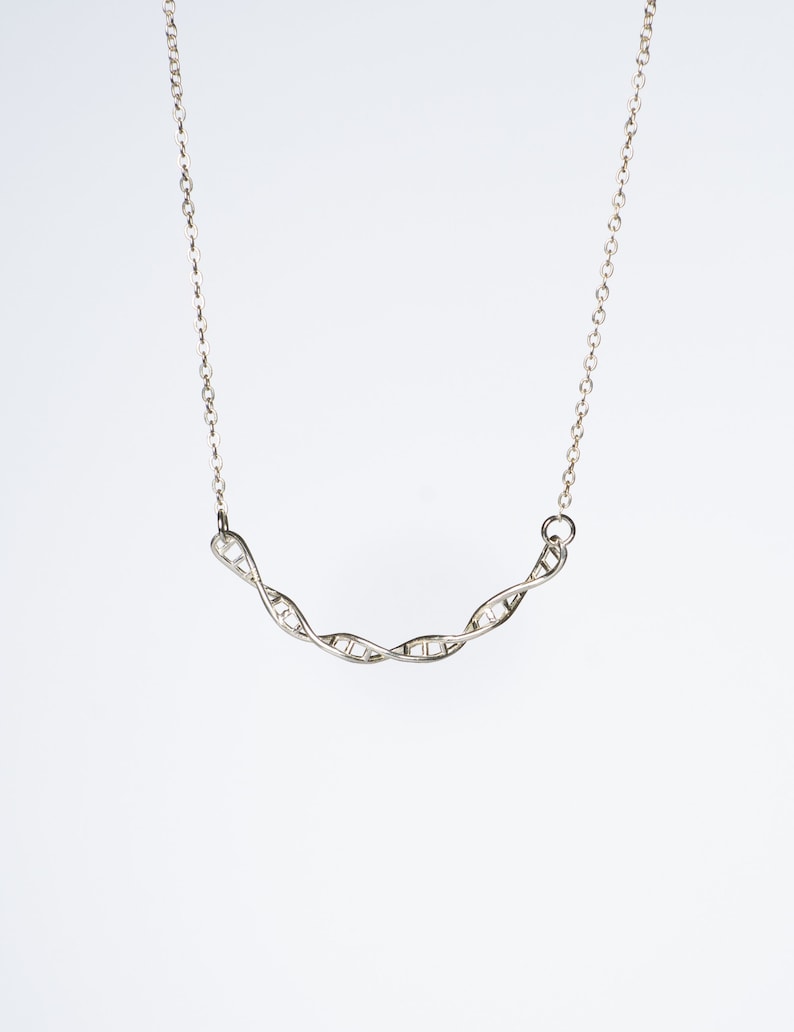 May include: A silver necklace with a double helix DNA pendant.