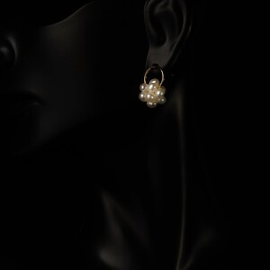 Peut inclure: Une paire de boucles d'oreilles cr&eacute;oles en or avec un groupe de perles blanches suspendues &agrave; chaque cr&eacute;ole.