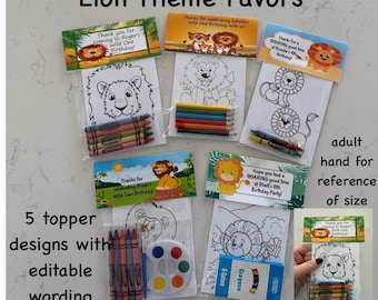 May include: Lion-themed party favors with five topper designs. Each favor includes a coloring page with a lion illustration and a set of crayons. The toppers feature text such as "Wild One Birthday" and "Roaring good time". An adult hand is shown for size reference.