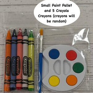 May include: A clear plastic bag contains a small white paint palette with six colored paint wells, five Crayola crayons, and a paintbrush. The crayons are orange, blue, red, white, and yellow. Text on the image reads "Small Paint Pallet and 5 Crayola Crayons (crayons will be random)".