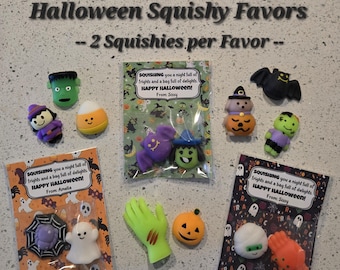 May include: Three Halloween-themed gift bags with colorful squishy toys inside. Each bag has a tag that says "SQUISHING you a night full of frights and a bag full of delights. HAPPY HALLOWEEN!" with a name at the bottom. The bags contain a variety of Halloween-themed squishies, including a ghost, a spider, a pumpkin, a witch, a bat, a candy corn, a Frankenstein, and a hand.