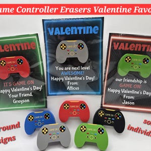May include: Three different Valentine's Day card designs featuring a game controller eraser. Each card has a neon background with the word "Valentine" at the top. The text on the cards reads: "It's Game On! Happy Valentine's Day! Your Friend, Greyson", "You are next level Awesome! Happy Valentine's Day! From: Atticus", and "Our friendship is Game On! Happy Valentine's Day! From: Jason".