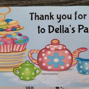 May include: A blue and white thank you card with the text "Thank you for coming to Della's Par-tea!"  The card features a teapot, teacups, and a tiered cake stand with cupcakes and macarons.