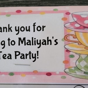 May include: Pink and white thank you card with a stack of three teacups and saucers. The card says "Thank you for coming to Maliyah's Tea Party!"