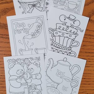 May include: A collection of black and white line art drawings featuring tea-themed illustrations. The drawings include teapots, teacups, cupcakes, and teddy bears, perfect for coloring or crafting projects.