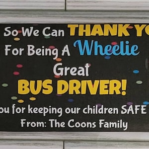 May include: A black and yellow chocolate bar wrapper with a school bus graphic and the text "So We Can THANK YOU For Being A Wheelie Great BUS DRIVER! Thank you for keeping our children SAFE all year! From: The Coons Family".