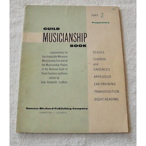 May include: A vintage "Guild Musicianship Book" with a two-tone green and beige cover. The book's title is in bold black letters. The cover lists musical topics such as scales, chords, and sight-reading. The book is from the Summy-Birchard Publishing Company.