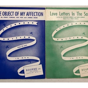 Puede incluir: Dos portadas de partituras antiguas. Una es azul con el título "The Object of My Affection" y la otra es verde con el título "Love Letters In The Sand". Ambas presentan un diseño de cinta blanca y estrellas.