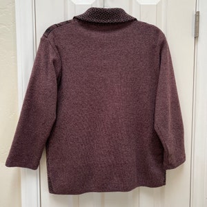 Puede incluir: Un su&eacute;ter de manga larga color burdeos con un cuello estampado en blanco y negro.