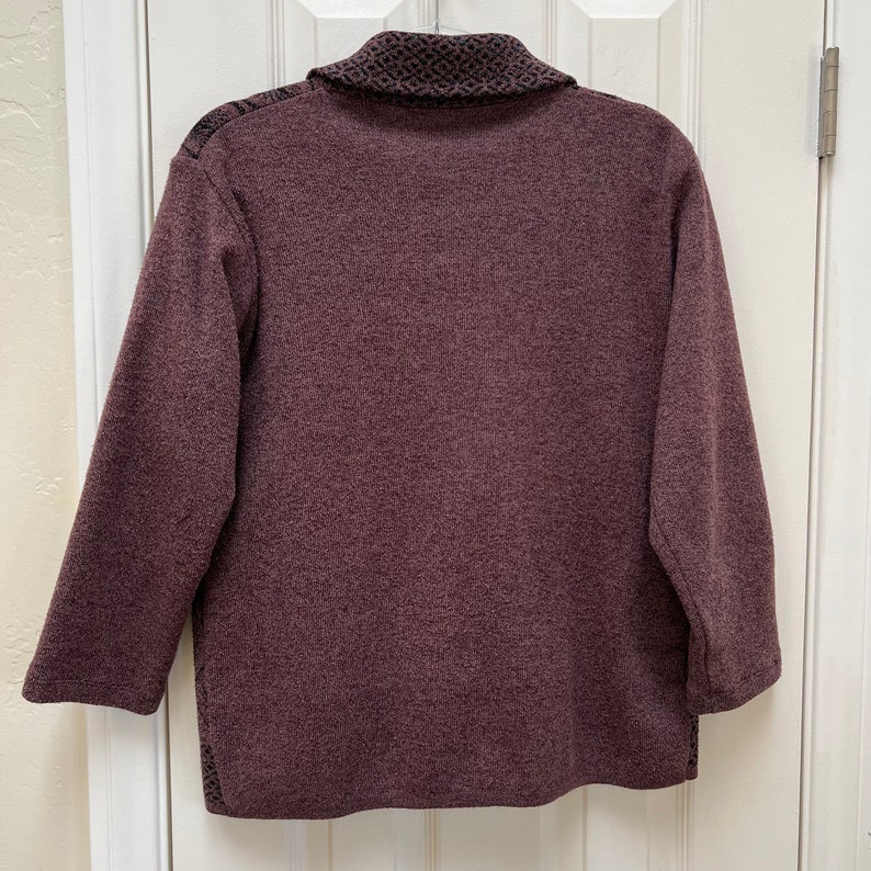 Puede incluir: Un su&eacute;ter de manga larga color burdeos con un cuello estampado en blanco y negro.