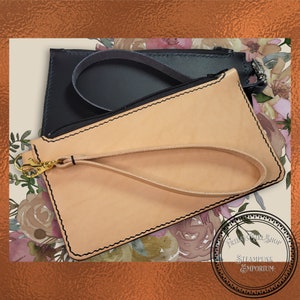 May include: Two leather purses, one tan and one black, with a zip fastening and a wrist strap. The purses are on a floral background with the text "Friday's Girl Shop Steampunk Emporium".