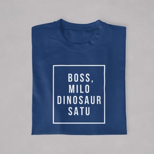 May include: A navy blue t-shirt with white text that reads "BOSS, MILO DINOSAUR SATU" in a white box.