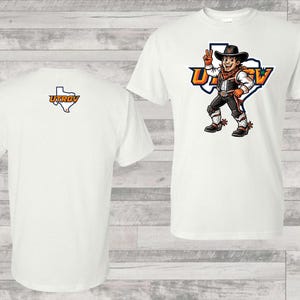 Puede incluir: Camisetas blancas con el logo de UTRGV. Una camiseta presenta la mascota de UTRGV con un atuendo de vaquero con el nombre de la universidad. La otra camiseta tiene el logo de UTRGV en la espalda, un contorno de Texas con el nombre de la universidad.