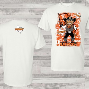 May include: White t-shirt featuring a cartoon cowboy mascot holding a flag that says "Rally the Valley." The shirt also has the text "UTRGV" and a Texas outline. The back of the shirt has the UTRGV logo.