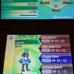 Pode incluir: Uma captura de tela de um videogame com o Pokémon Lucario. A tela exibe as estatísticas de Lucario, incluindo HP, Ataque e Defesa, junto com seu conjunto de movimentos. A interface do jogo é visível.
