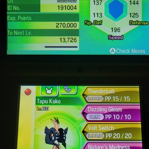 May include: A screenshot of a Nintendo 3DS game showing a Tapu Koko Pokemon with its stats and moves. The Pokemon is level 60 and has the moves Thunderbolt, Dazzling Gleam, Volt Switch, and Nature's Madness.