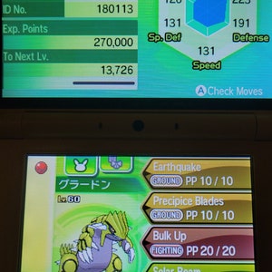 Puede incluir: Una captura de pantalla de un videojuego que muestra a un Groudon de nivel 60, un Pokémon de tipo tierra, con los movimientos Terremoto, Hojas de Acantilado, Fortalecer y Rayo Solar. Las estadísticas del Pokémon se muestran, mostrando sus PS, ataque, defensa, ataque especial, defensa especial y velocidad.