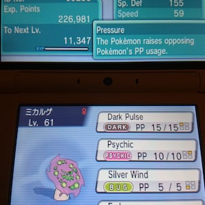 May include: A handheld gaming device screen showing a Pokémon battle interface. Spiritomb is displayed with stats and moves like Dark Pulse and Psychic. The game interface is in Japanese.