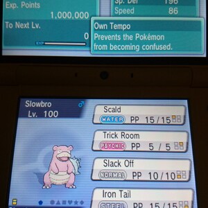 Pode incluir: Uma captura de tela de um jogo de Nintendo DS mostrando um Pokémon Slowbro com o texto "Slowbro Lv. 100" e "Slowbronite". O Pokémon é rosa e tem uma concha azul. A tela do jogo mostra as estatísticas e os movimentos do Pokémon, incluindo "Scald", "Trick Room", "Slack Off" e "Iron Tail".
