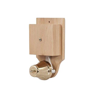 Può includere: Un campanello in legno con una campana in ottone e un cordino. La campana è montata su una base di legno chiaro. Il design è semplice e classico, adatto per l'ingresso di una casa o di un'attività commerciale.