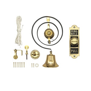 Könnte beinhalten: Ein antikes Türklingel-Set aus Messing, bestehend aus einer Glocke, einem Seilzugsystem und einer Wandplatte. Auf der Platte steht "RING BELL PULL". Das Set enthält Befestigungsmaterial und ein weißes Seil. Die Glocke hängt an einer schwarzen Metallspirale.