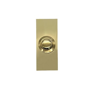 May include: A gold-coloured doorbell button with a round, raised button in the centre.