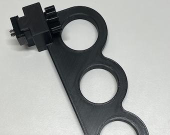May include: Black plastic 3D printed camera mount with three circular holes and a cold shoe mount.